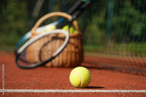 Tennis rackets and ball on court 