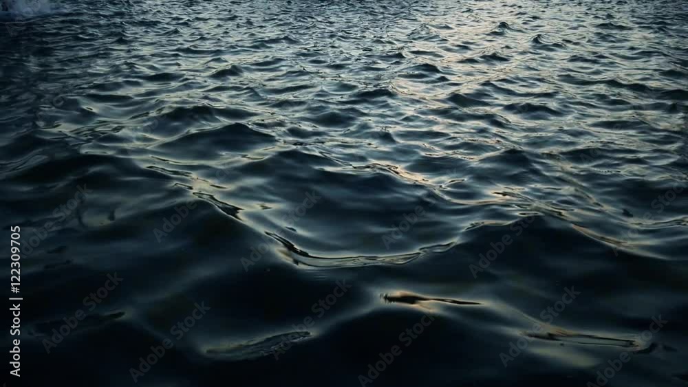 A calm water surface at dusk in slow motion.