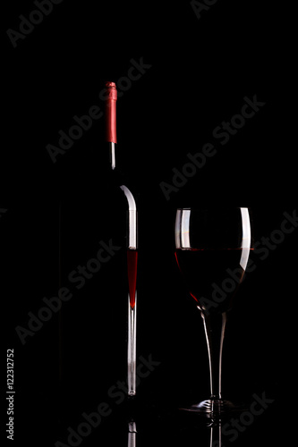 Red wine glass and bottle silhouette isolated on black background