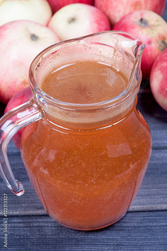 fresh squeezed apple juice in the pitcher on wooden table fresh squeezed apple juice in the pitcher on wooden table