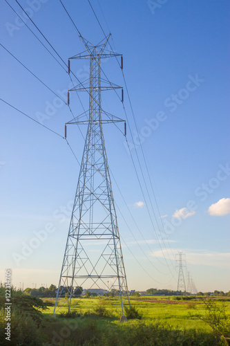 Electricity pylon silhouetted against blue sky wih cloud background. High voltage tower © Voy_ager