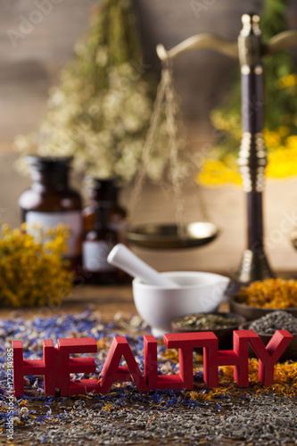Healthy herbs on wooden table, mortar and herbal medicine