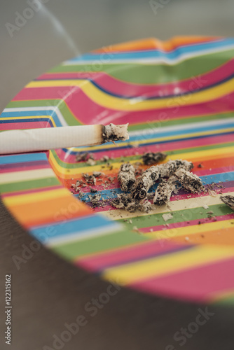 Cigarette in the colorful ashtray 