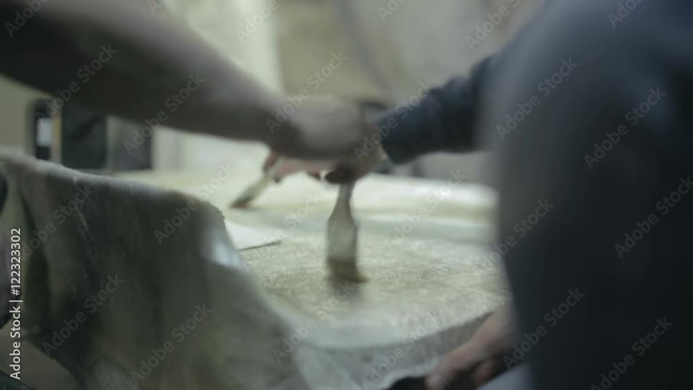 Workers apply varnish