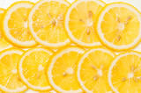 Background of fresh yellow lemon slices on white