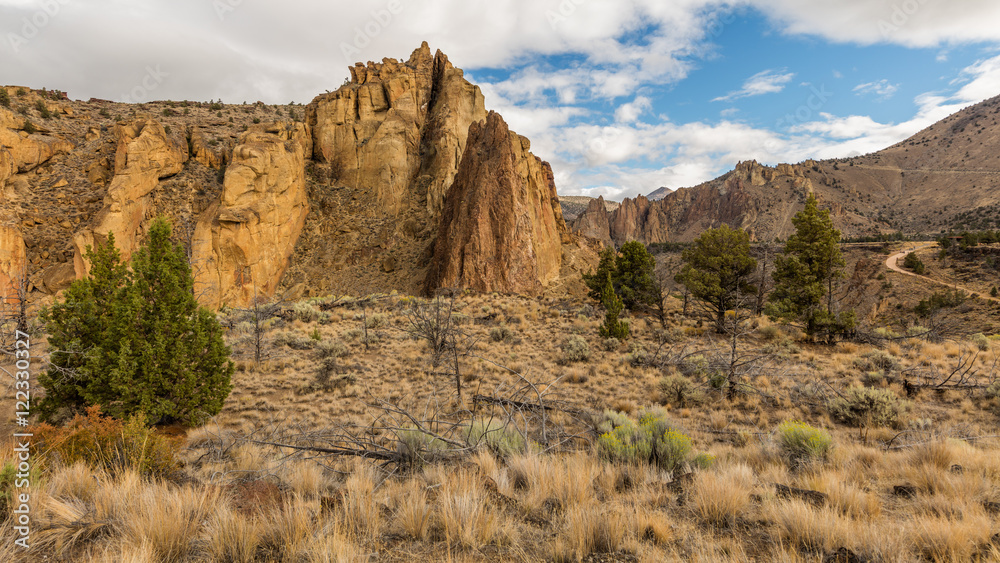 The sheer rock walls. Beautiful landscape of yellow sharp cliffs. Dry yellow grass grows on the slopes of the mountains. Smith Rock state park, Oregon