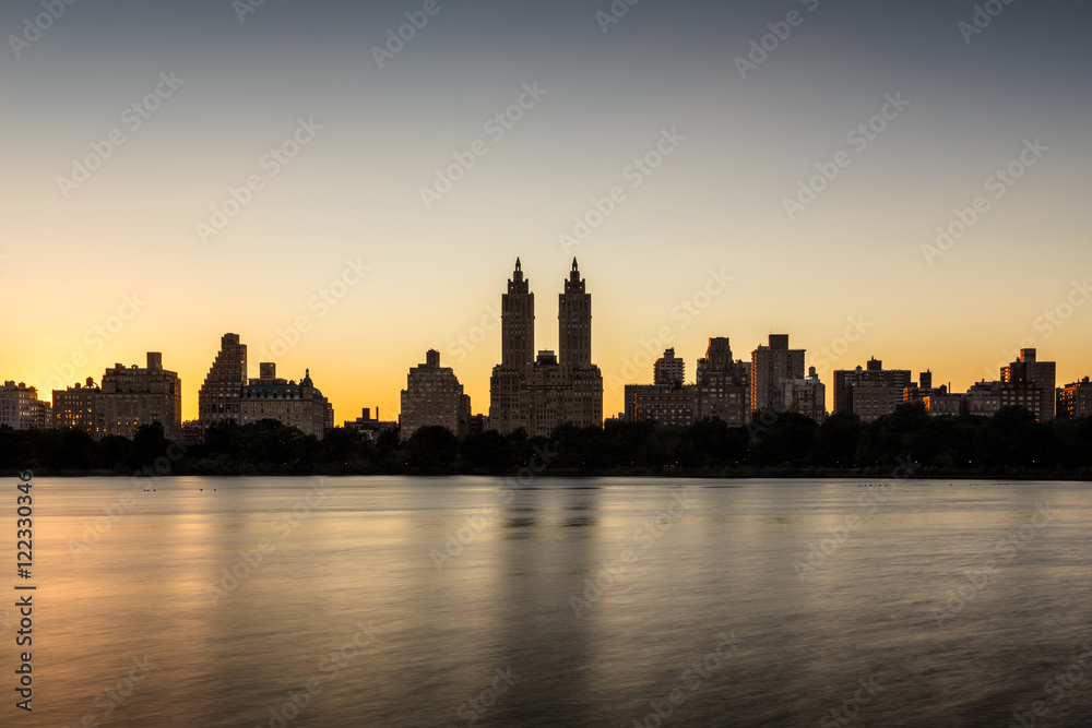 Obraz premium Upper West Side buildings and Central Park Jacqueline Kennedy Onassis Reservoir at sunset. Manhattan, New York City