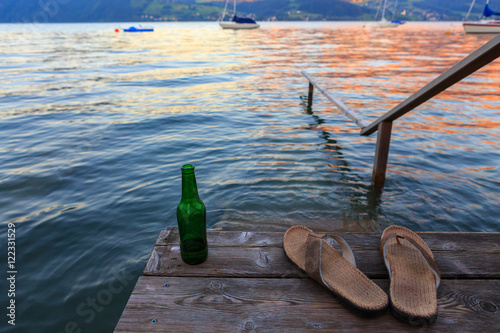 Steg mit Flip Flops, Getränk mit Bergpanorama
