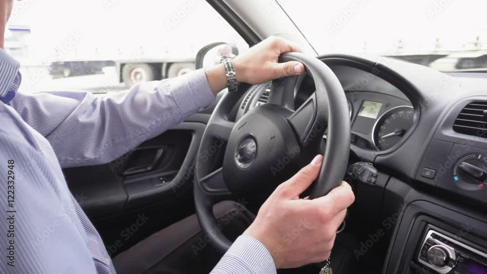 Close up of business man's hands driving a modern car, turning the steering wheel in slow motion. Business trip concept. Close up of business man's hands driving a modern car, turning the steering wheel in slow motion. Business trip concept.
