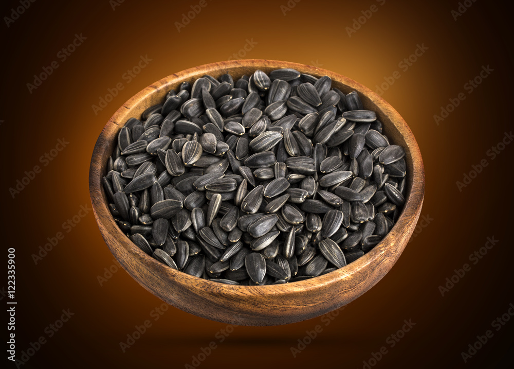 Sunflower seeds in bowl isolated on black background Sunflower seeds in bowl isolated on black background