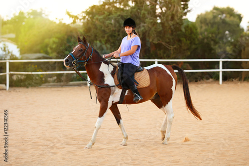 A Young girl getting a horseback riding lesson