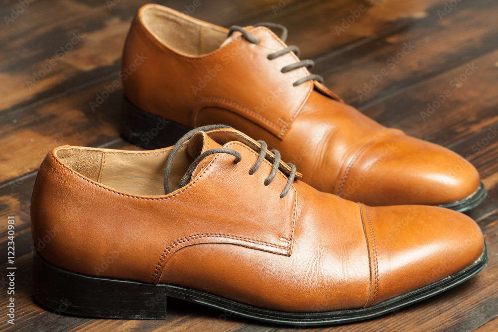 Men's leather shoes on a wooden floor