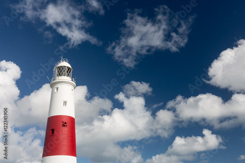 The lighthouse at Portland Bill in Dorset with a cloudy sky behind.