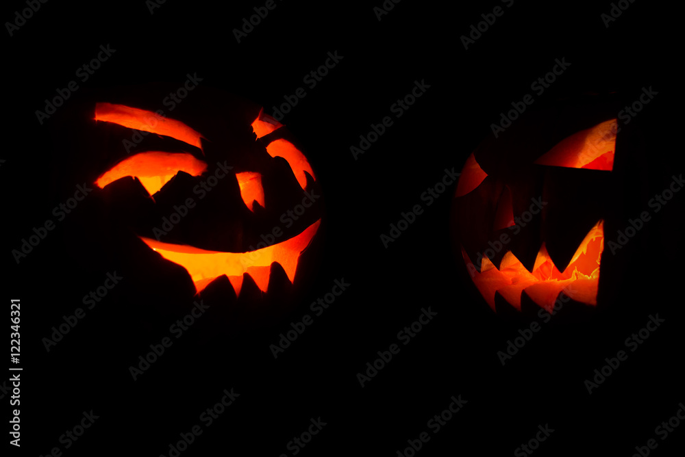 two carved face of pumpkin glowing on Halloween black background two carved face of pumpkin glowing on Halloween black background