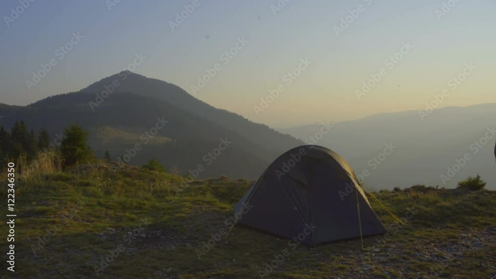 2 in 1 video! The man stand near the tent on the background of mountain landscape. Real time capture. Wide angle 2 in 1 video! The man stand near the tent on the background of mountain landscape. Real time capture. Wide angle