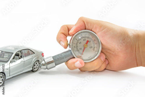 Men holding pressure gauge and checking air pressure of small car model.