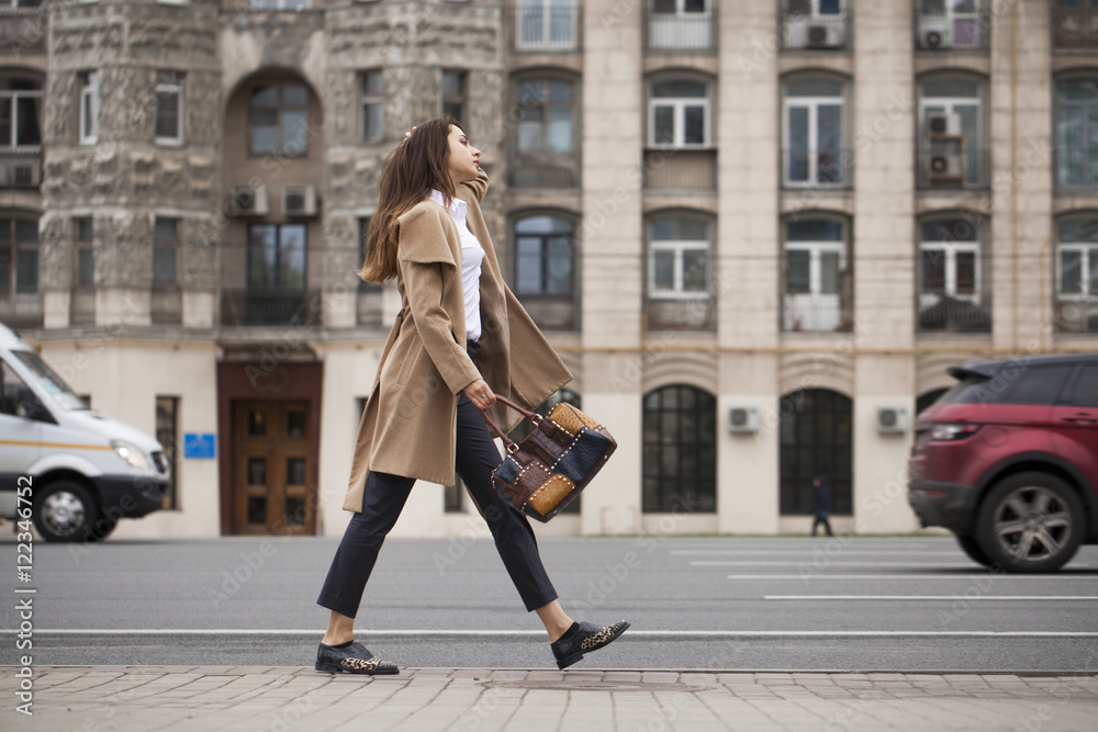 Fototapeta premium Portrait of a young beautiful woman in beige coat