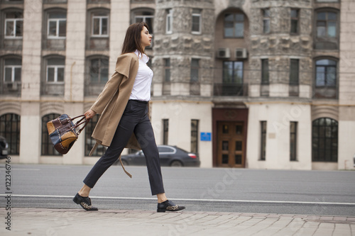 Portrait of a young beautiful woman in beige coat © Andrey_Arkusha