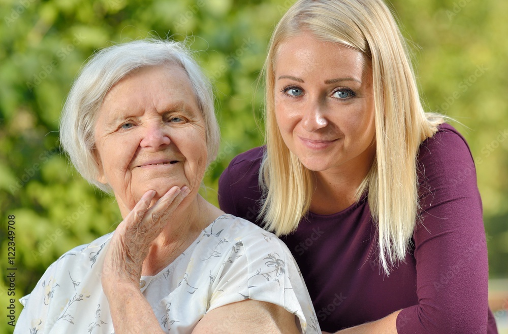 Grandmother and granddaughter. Young woman carefully takes care