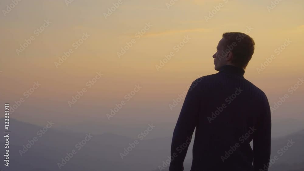 2 in 1 video! The man stand on the top of the mountain against the background of sunset. Real time capture. Wide angle 2 in 1 video! The man stand on the top of the mountain against the background of sunset. Real time capture. Wide angle