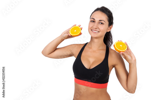 Girl with ponytail holding two halves of orange