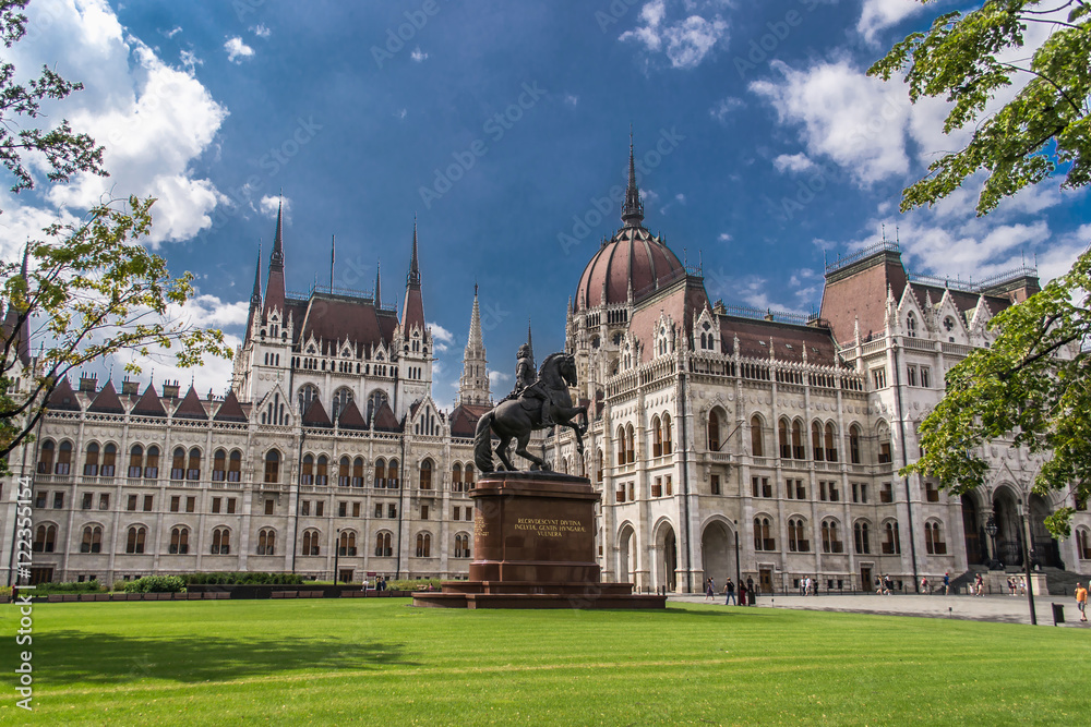 Green grass, monument and architecture of hungarian parliament