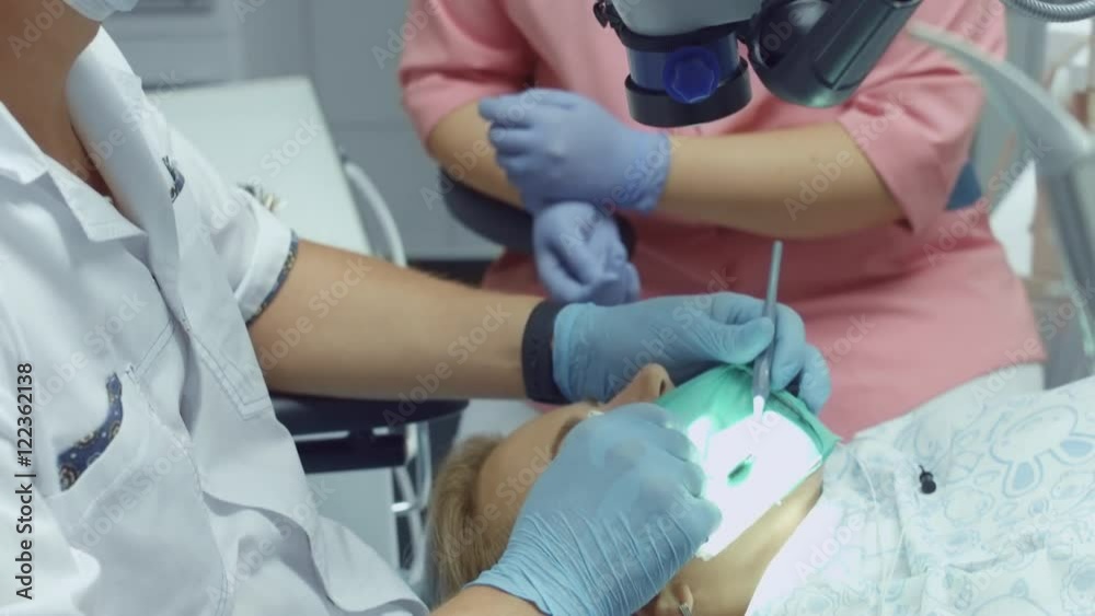 Process of filling the sick tooth of the patient using modern dental equipment Process of filling the sick tooth of the patient using modern dental equipment