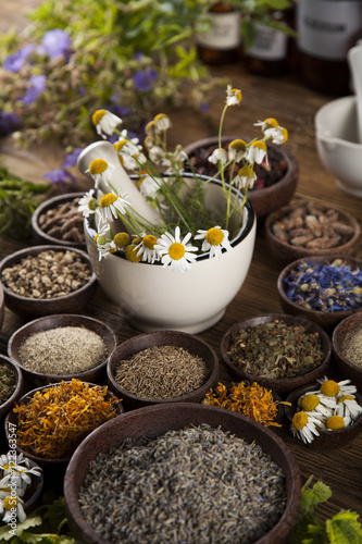 Natural medicine, herbs, mortar on wooden table background