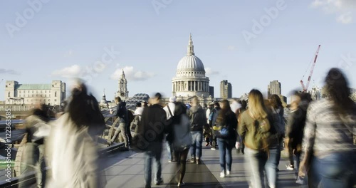 Time lapse view of the Millennium bridge in London with St Paul cathedral and tourists and commuters walking