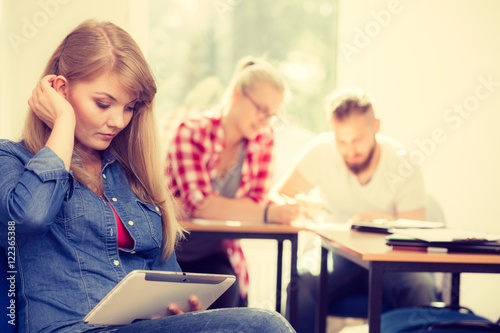 Student girl with tablet in front of her classmates