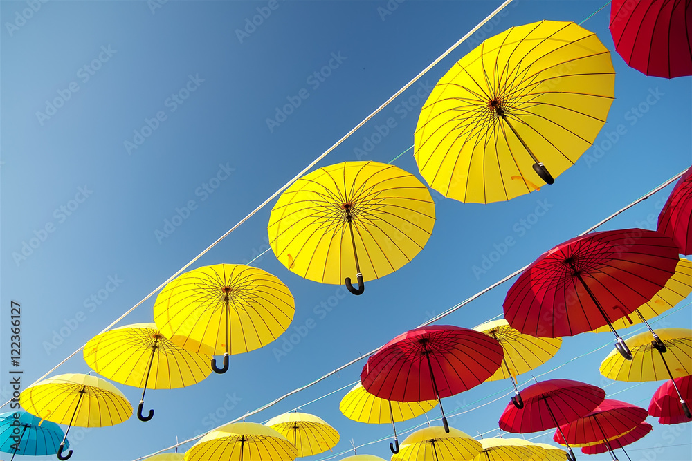 Obraz premium colorful umbrellas under the beautiful cloudy sky. 