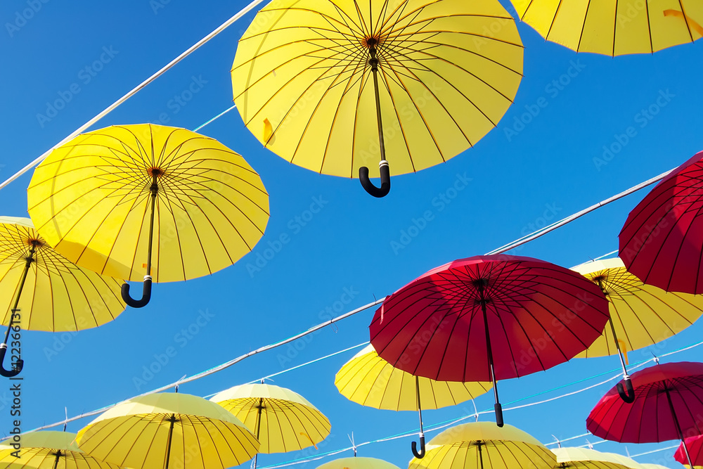 Obraz premium colorful umbrellas under the beautiful cloudy sky. 