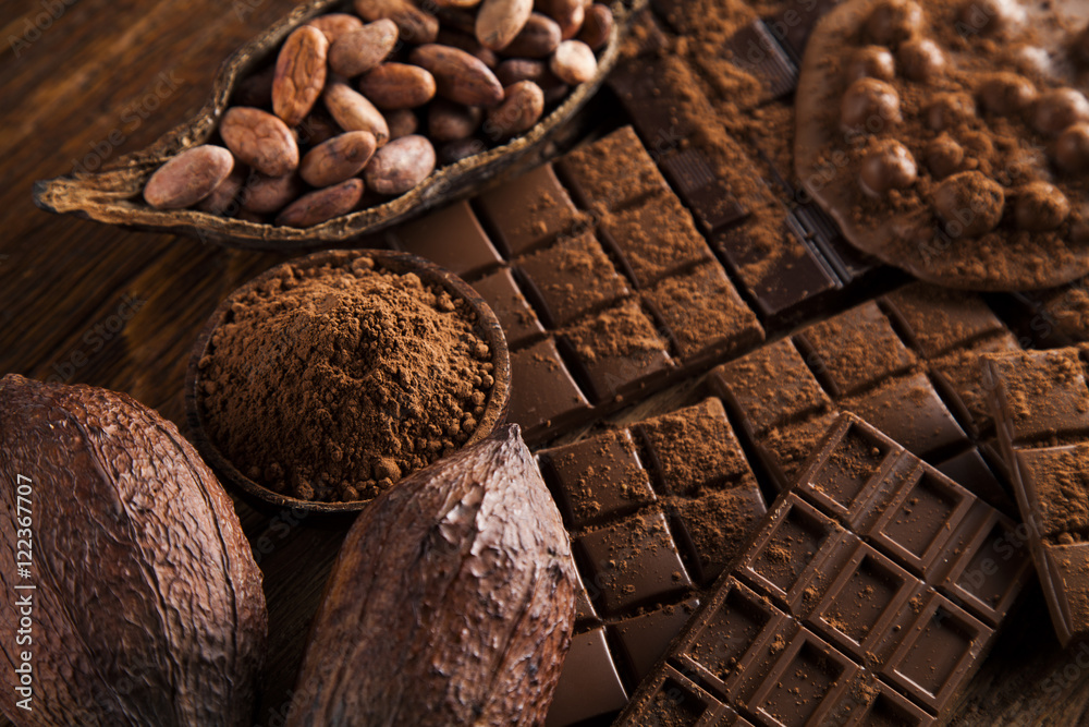 Dark homemade chocolate bars and cocoa pod on wooden Dark homemade chocolate bars and cocoa pod on wooden