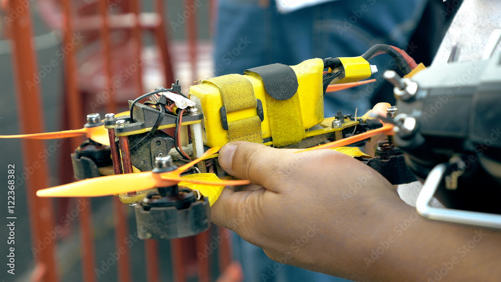 Close up of modern handmade FPV drone in man's hands. Preparing for flight on drone competition outdoors. Quadrocopter control training. Close up of modern handmade FPV drone in man's hands. Preparing for flight on drone competition outdoors. Quadrocopter control training.