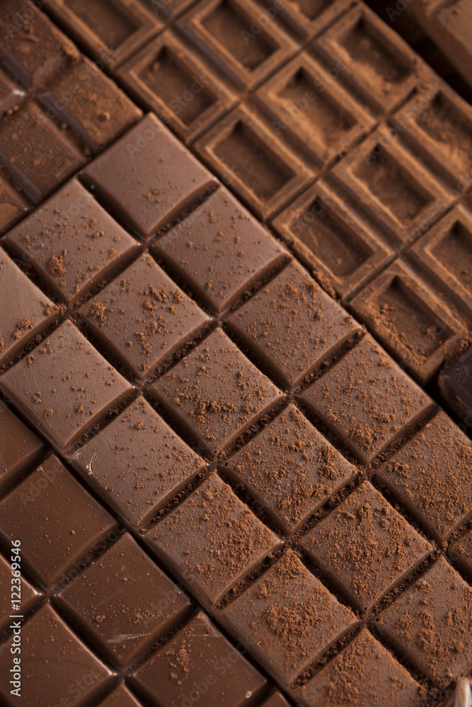 Dark homemade chocolate bars and cocoa pod on wooden
