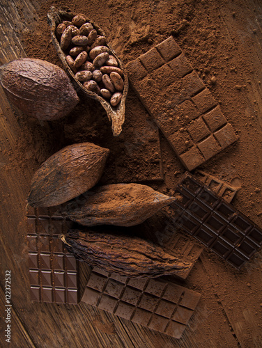 Chocolate bar, candy sweet, cacao beans and powder on wooden bac