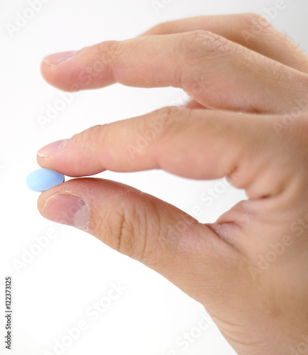 Male hand with blue pills