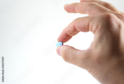 Male hand with blue pills