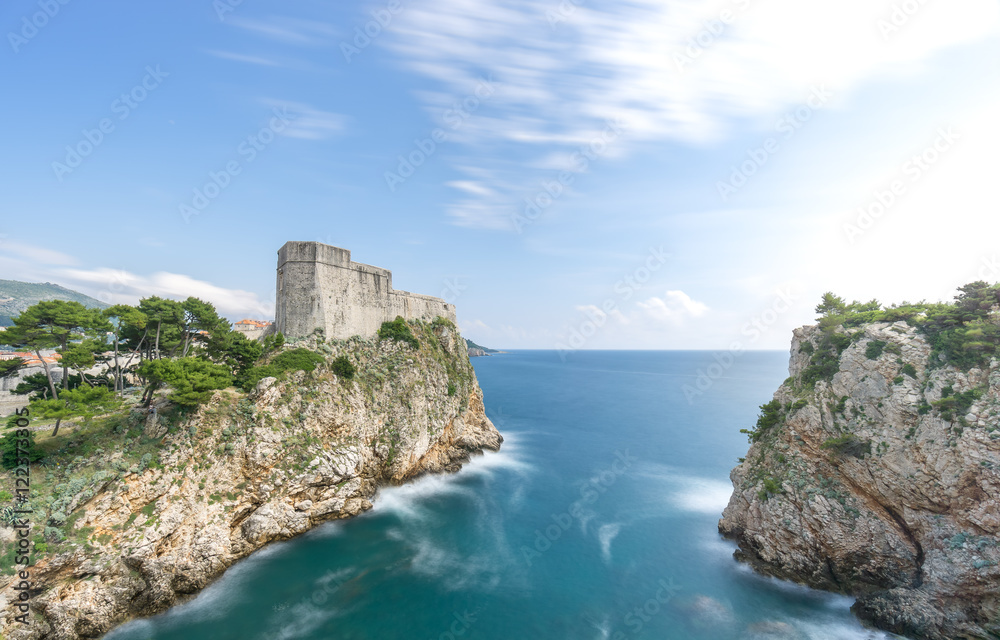 The city walls of Dubrovnik in Croatia with the forts and bay of Kolorina visible on a summer day.