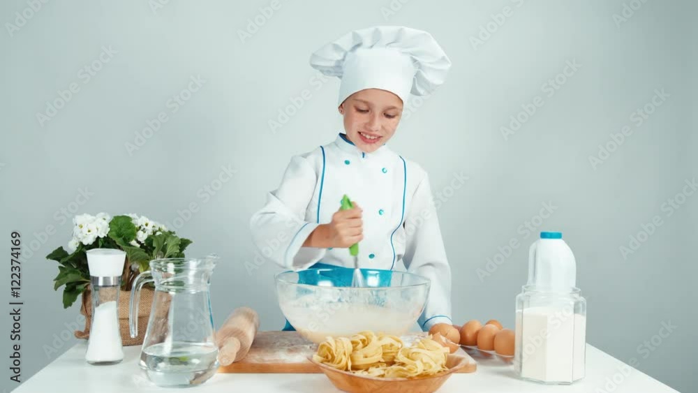 Young baker making dough and smiling at camera isolated on white Young baker making dough and smiling at camera isolated on white