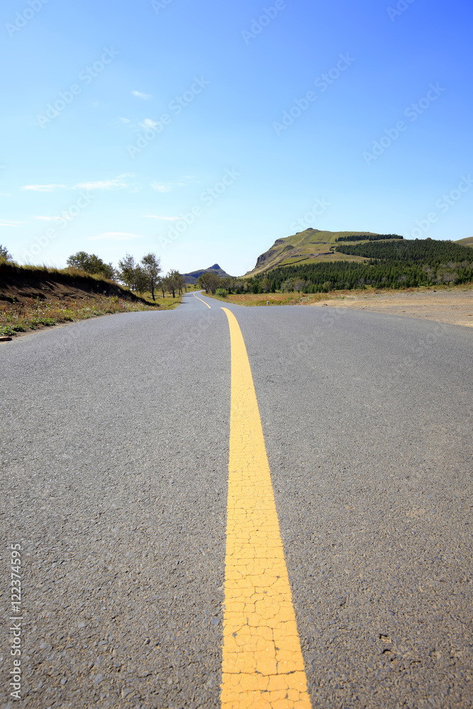 asphalt road on grassland