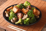 Fried tofu cheese with broccoli, mushrooms and teriyaki sauce close-up. Horizontal
