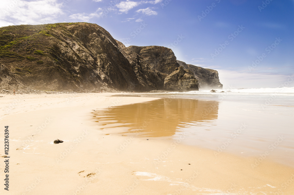reflection over the sand, view of a beach in algarve with reflection of the cliffs. algarve , portugal reflection over the sand, view of a beach in algarve with reflection of the cliffs. algarve , portugal