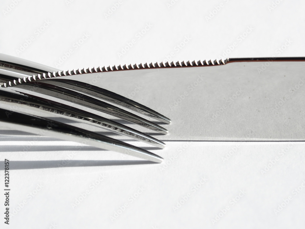 Naklejka premium Knife and fork reflection on white background
