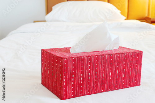 red tissue paper box on spacious bed