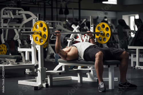Muscular well built sportsman pushing weight