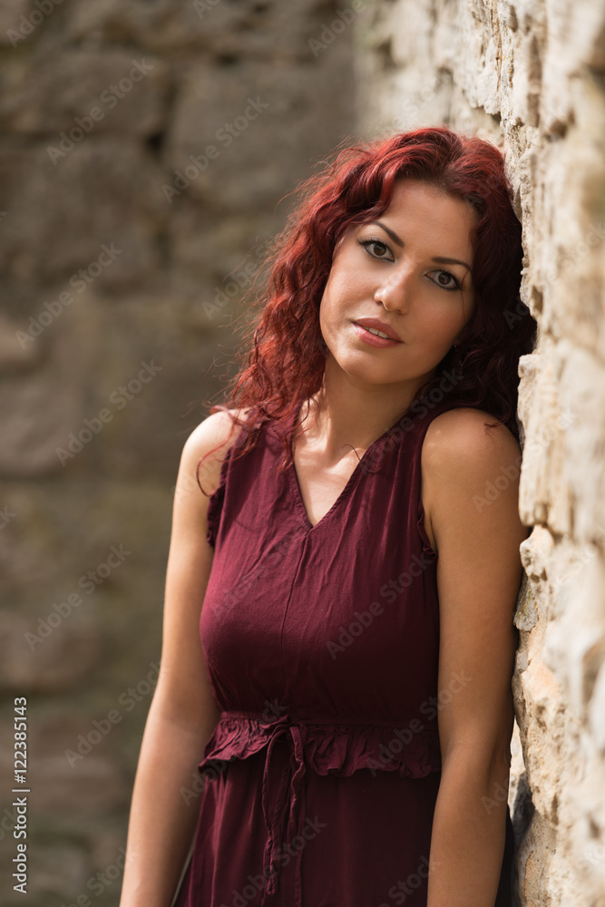 Fototapeta premium Beautiful young woman with red hair in the park