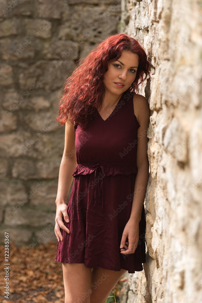 Beautiful young woman with red hair in the park