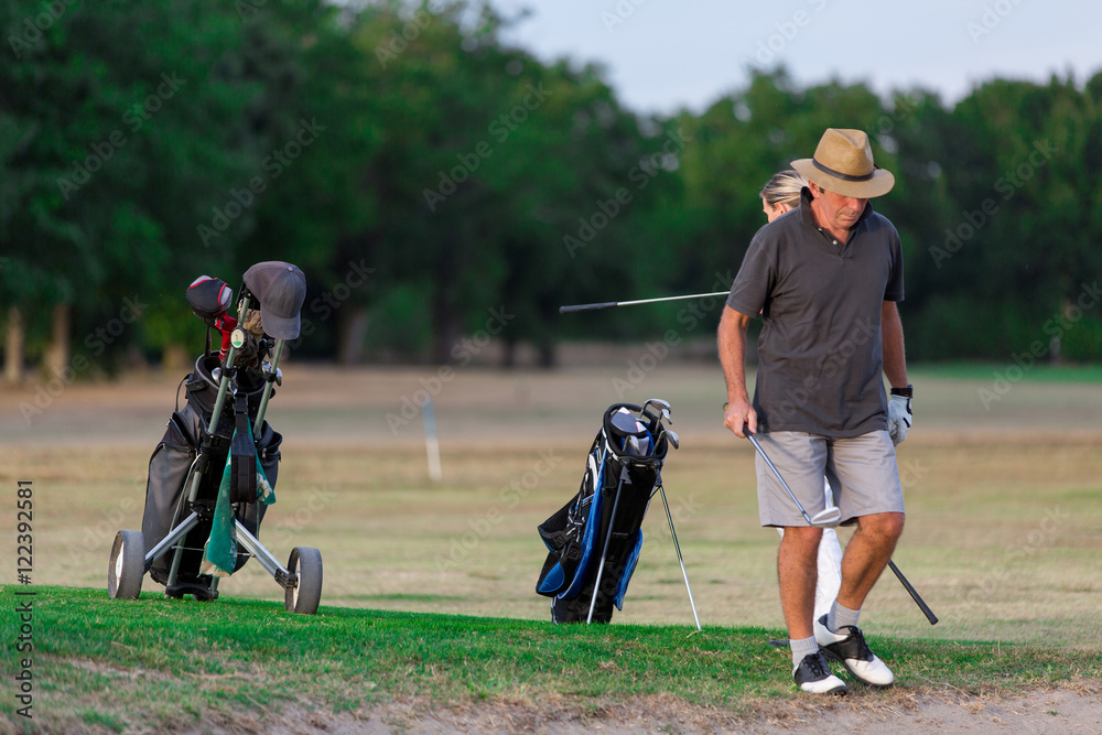 Couple Enjoying A Game Of Golf Couple Enjoying A Game Of Golf