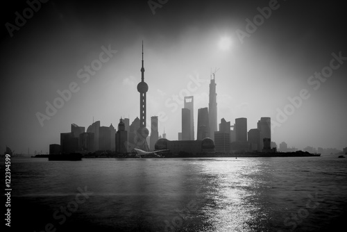 Shanghai sunrise silhouette with Oriental Pearl Tower, Huangpu River, Pudong district, Shanghai, China. Black and White, Long exposure with ND Grad filter, visible noise.